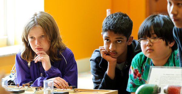 Three middle school students in a science lab